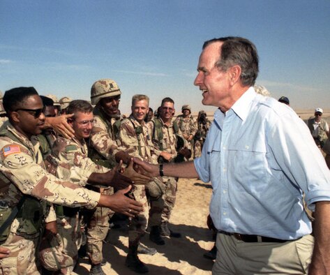 President George H.W. Bush shakes hands with U.S. troops.