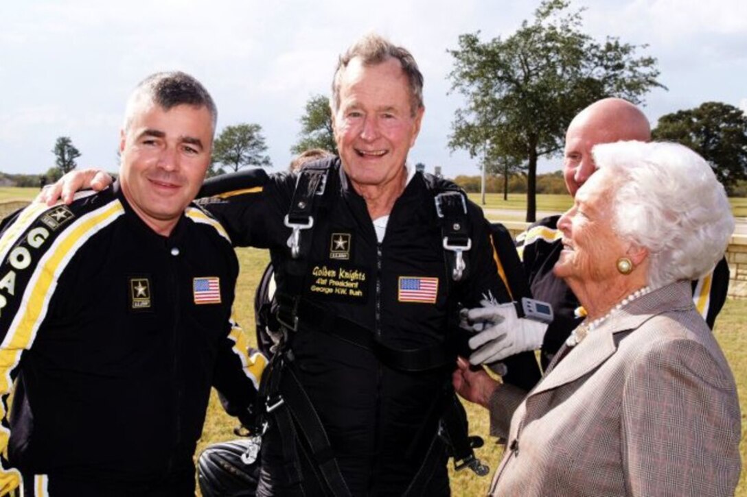 Former President George H.W. Bush and First Lady Barbara Bush pose with a soldier.