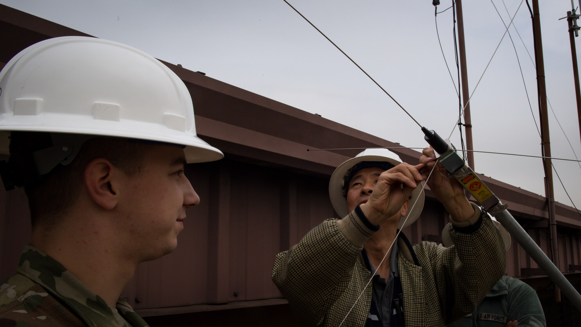 U.S. Air Force Airman 1st Class Jesse Slater, left, and Yong Ui Song, fire alarm technicians with the 51st Civil Engineer Squadron, assemble a new AS1 antenna before installing it at the fire department on Osan Air Base, Republic of Korea, Nov. 29, 2018.