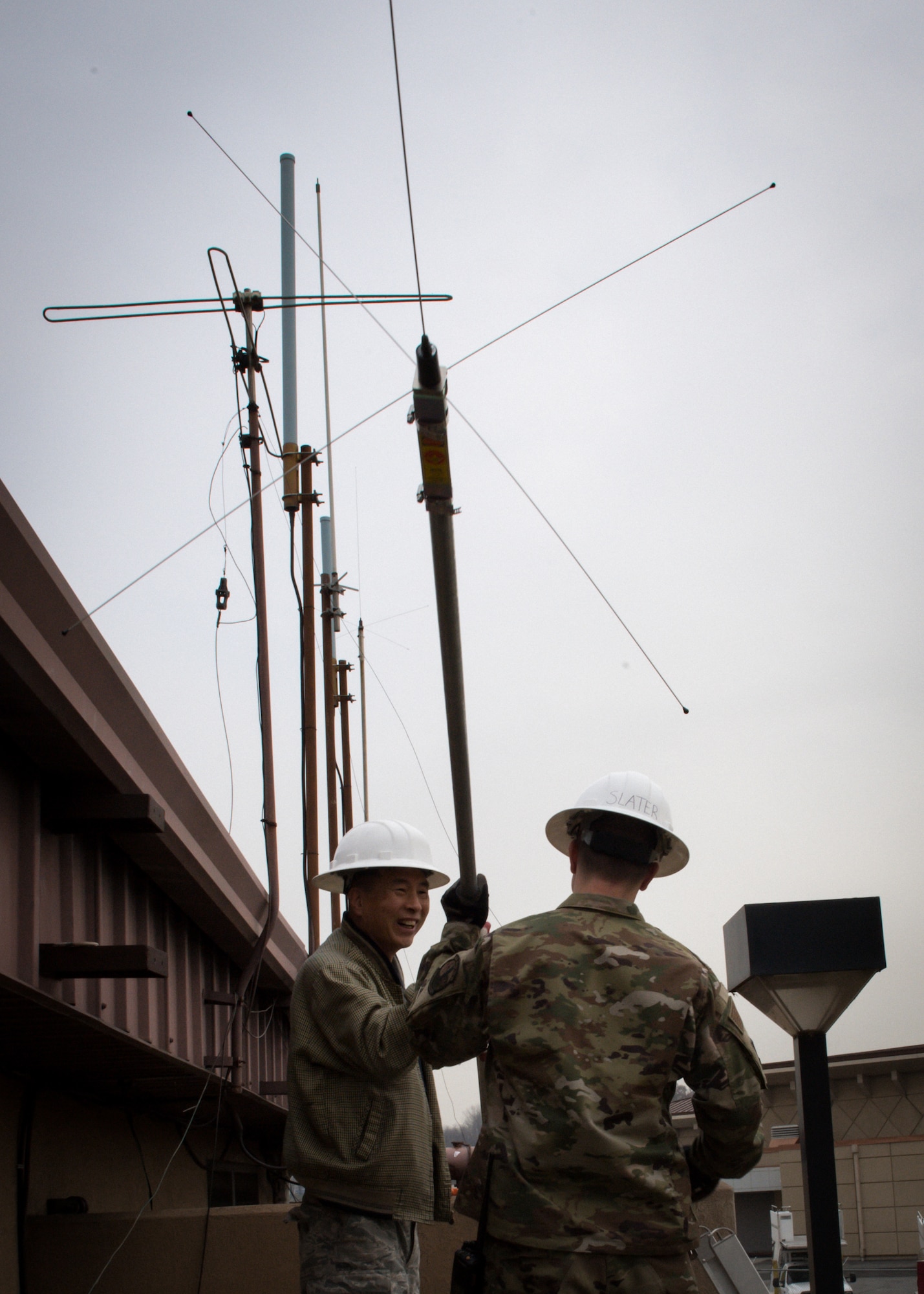Yong Ui Song, left, and U.S. Air Force Airman 1st Class Jesse Slater, fire alarm technicians with the 51st Civil Engineer Squadron, assemble an AS1 antenna at the fire department on Osan Air Base, Republic of Korea, Nov. 29, 2018.
