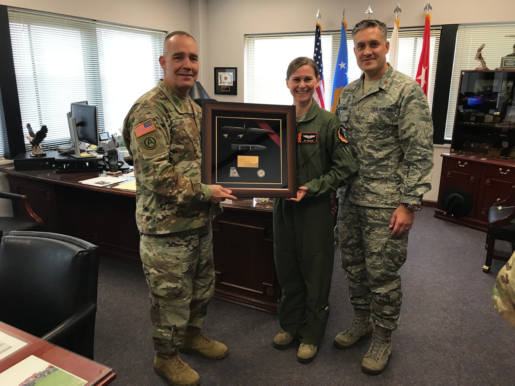 Maj. Mark Williams (far right), 132d Intelligence Surveillance Reconnaissance Group, and Maj. Jen Williams, JFHQ, present a WWI trench knife to Maj. Gen. Timothy Orr (left), adjutant general of Iowa, November 20, 2018, at Joint Force Headquarters in Johnston, Iowa. It was presented to commemorate the 100th anniversary of World War I. (U.S. Air National Guard photo by Staff Sgt. Michael J. Kelly)