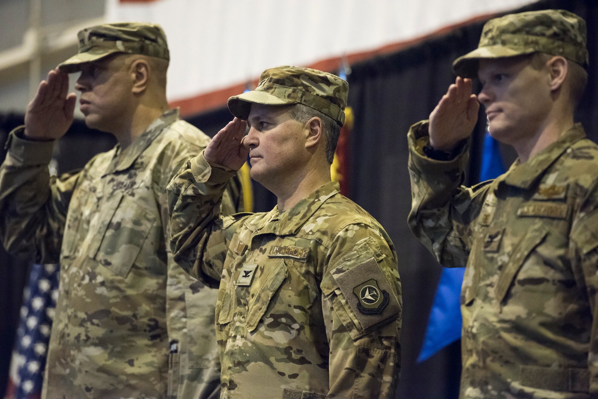 U.S. Army Maj. Gen. Michael C. Thompson, Oklahoma Adjutant General, U.S. Air Force Col. Devin R. Wooden, outgoing commander of the 137th Special Operations Wing, and incoming commander Col. Daniel R. Fowler, 137th SOW, salute during the national anthem at the beginning of the change of command ceremony at Will Rogers Air National Guard Base, Okla., Dec. 1, 2018. Fowler is the 17th commander of the Wing it its history and is only the second wing commander since coversion to a special operations wing in 2015. (U.S. Air National Guard photo by Tech. Sgt. Caroline Essex/Released)