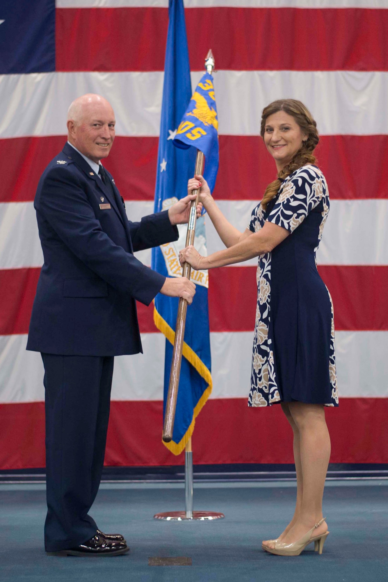 Dr. Tess VanHoy, 307th Medical Squadron honorary commander, accepts the unit guidon from Col. Louis Fehl, 307th MDS commander, during an induction ceremony at Barksdale Air Force Base, Louisiana, Dec. 1, 2018.  VanHoy, serves as a medical doctor in the Shreveport and is the first honorary commander of the 307th MDS. (U.S. Air Force photo by Master Sgt. Ted Daigle)