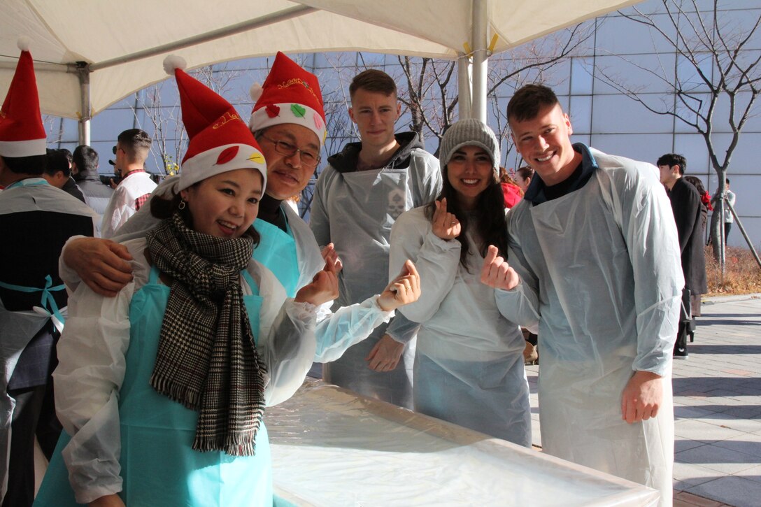 SEONGNAM, Republic of Korea – U.S. Marines Corps Forces Korea and Republic of Korea government organizations, private entities, and citizens make a little hear hand gesture to show support for charity and unity during Kimchi Fest here, Nov. 30.  The Department of Agriculture, Food and Rural Affairs; Asia Leaders Forum for Science; and MARFORK put together the Kimchi Fest to make Kimchi for elderly and less fortunate Koreans.