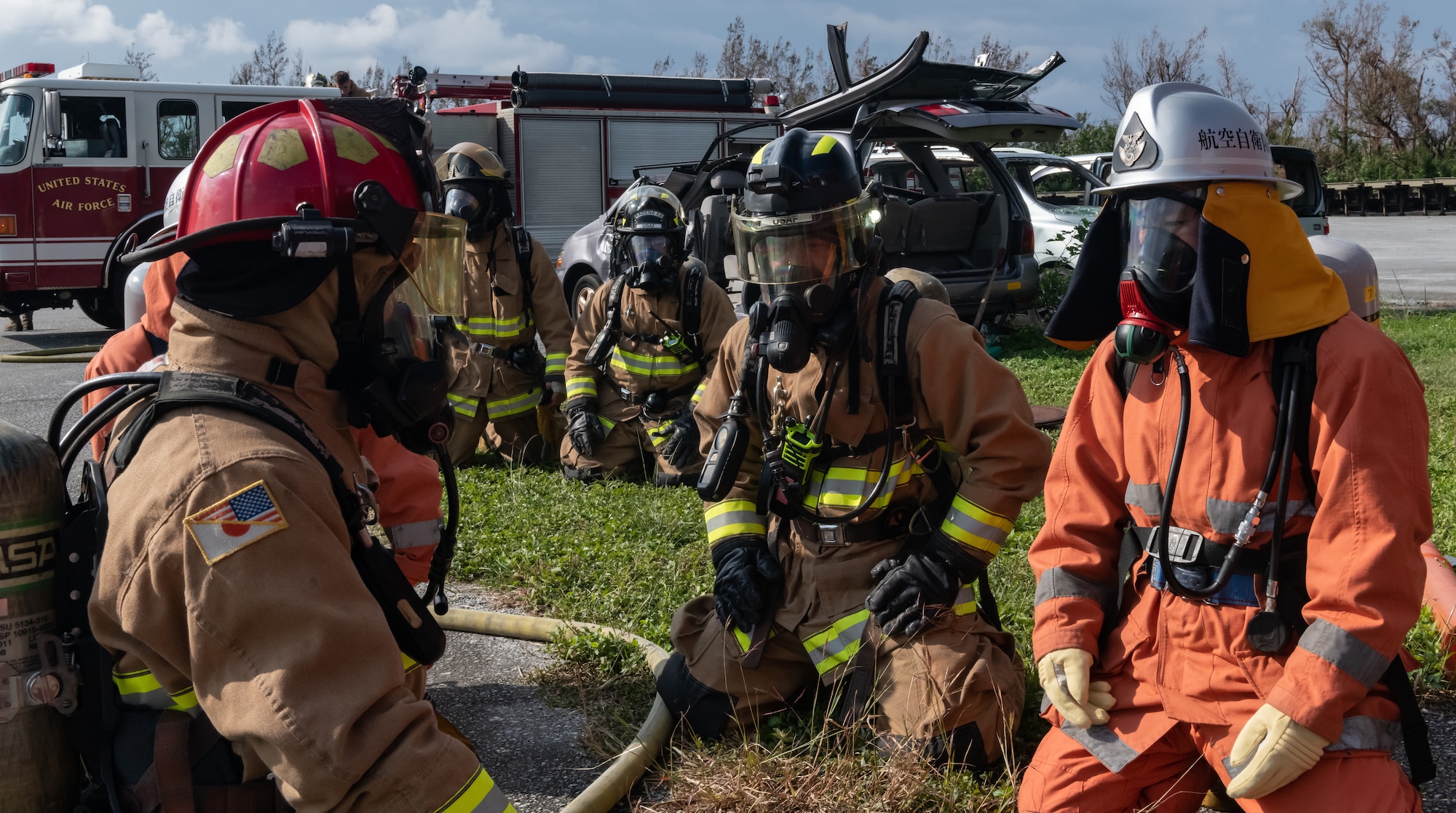 U.S. Air Force firefighters from the 18th Civil Engineer Squadron and Japan Air Self Defense Force firefighters from the 9th Wing, Naha Air Base, Japan, prepare to start structural live fire training Nov. 15, 2018, at Kadena Air Base, Japan. The training enabled both units to hone their techniques, meet annual requirements, develop communication skills and foster team building. (U.S. Air Force photo by Staff Sgt. Micaiah Anthony)