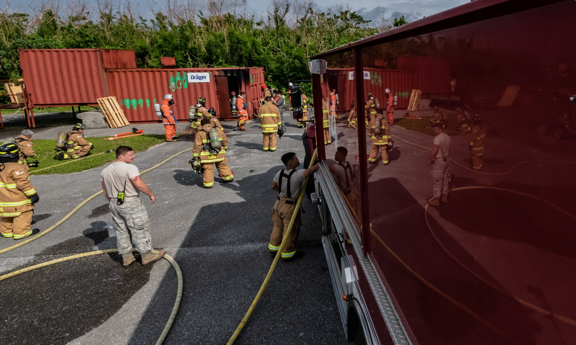 U.S. Air Force firefighters from the 18th Civil Engineer Squadron and Japan Air Self Defense Force firefighters from the 9th Wing, Naha Air Base, Japan, conduct structural live fire training Nov. 15, 2018, at Kadena Air Base, Japan. During the training firefighters used hand signals and gestures to communicate.(U.S. Air Force photo by Staff Sgt. Micaiah Anthony)