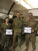 Maj. Michael Lasher (center), 451st Expeditionary Aircraft Maintenance Squadron commander, notifies Airman 1st Class Gina Louise and Airman 1st Class Dane Richards of their promotion to Senior Airman “Below the Zone” at Kandahar Airfield, Afghanistan. (courtesy photo)