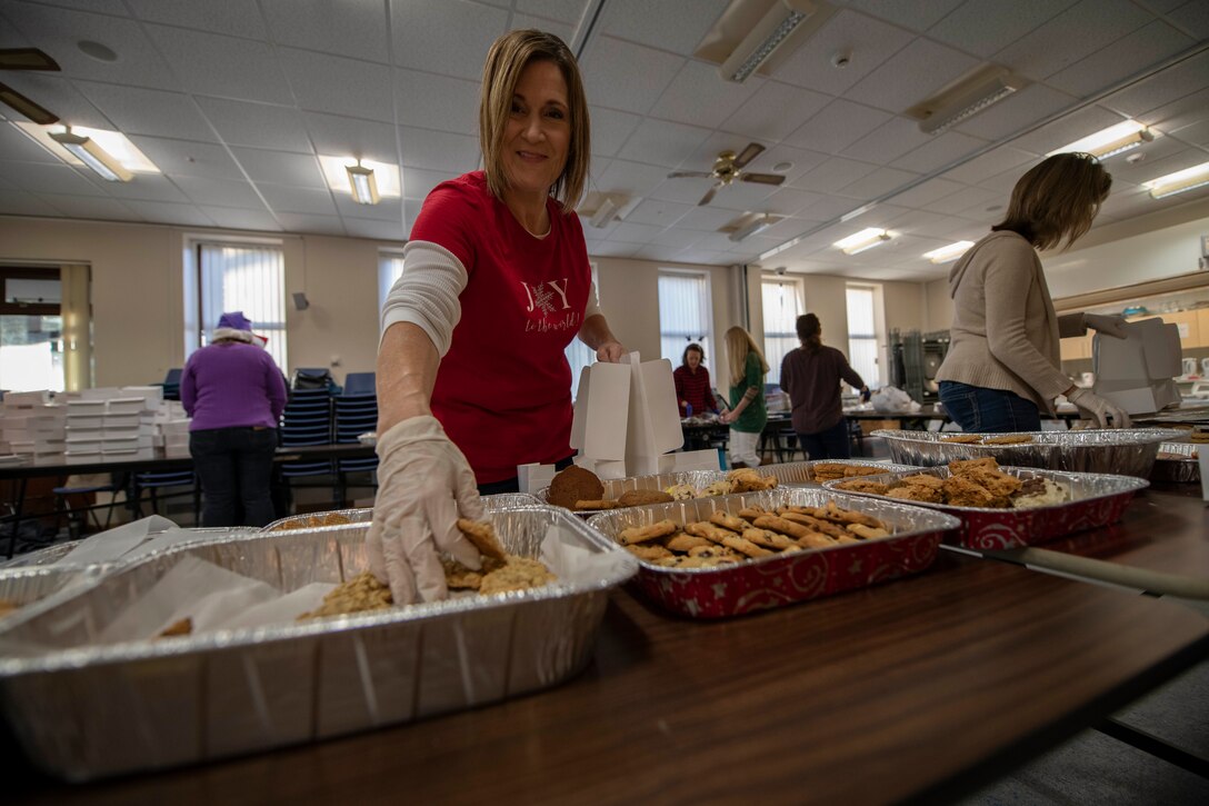 Jennifer Worley, wife of U.S. Air Force Chief Master Sgt. James Worley, 352nd Special Operations Maintenance Group chief enlisted manager, packs cookies during the annual RAF Mildenhall Cookie Drive at the base chapel on RAF Mildenhall, England, Dec. 12, 2018. Team Mildenhall Airmen and families donated cookies for Airmen who live in the dorms. (U.S. Air Force photo by Senior Airman Luke Milano)
