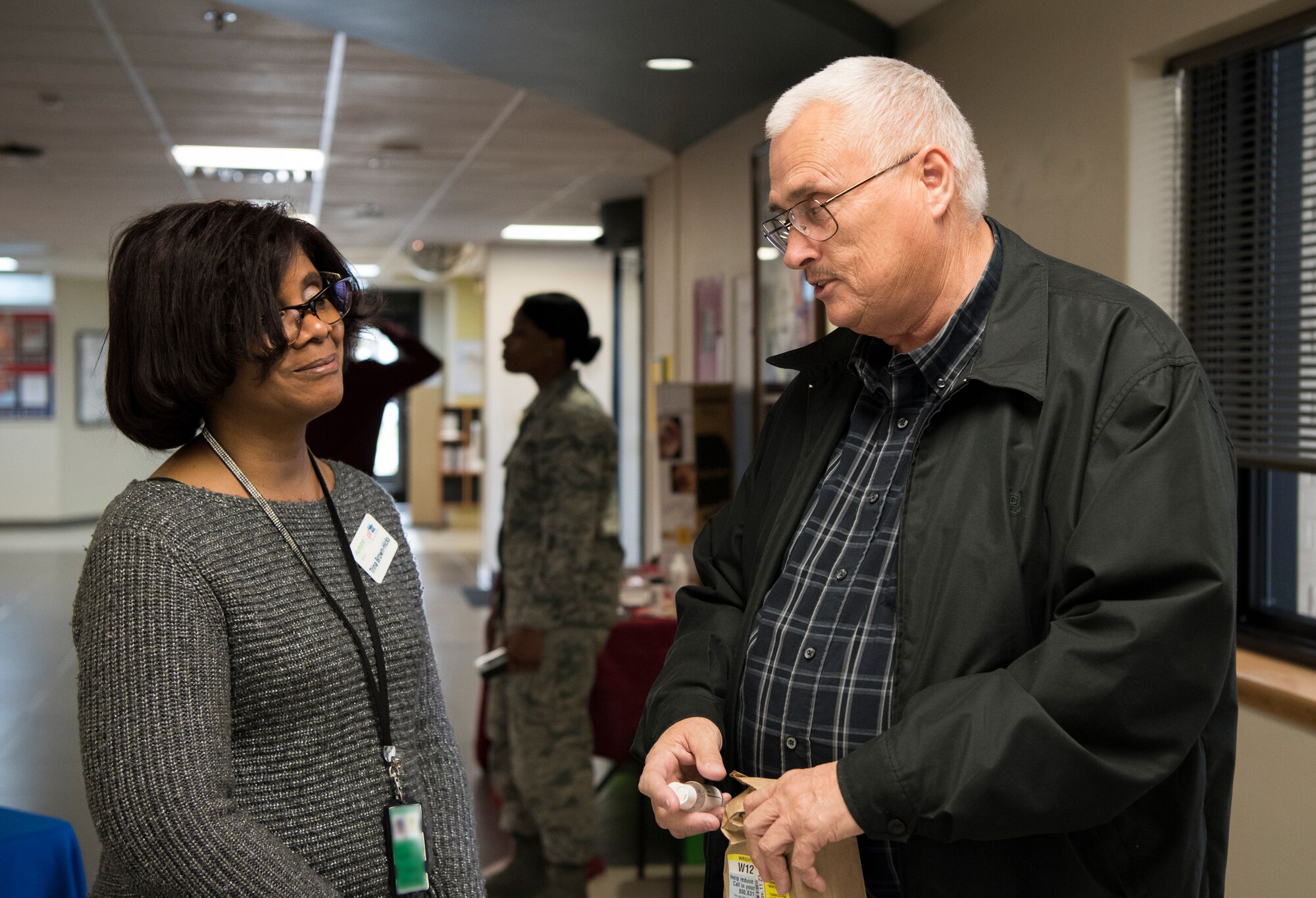 Trina Brown-Hicks, Humana health systems manager, speaks with Phillip R. Wright, attendee, during the 436th Medical Group Health Fair on Nov. 27, 2018, at Dover Air Force Base, Del. Attendees were offered free medical information on topics such as diabetes, disease management, dental health and cervical cancer. (U.S. Air Force photo by Airman 1st Class Zoe M. Wockenfuss) (This image has been obscured to protect personal identification information)