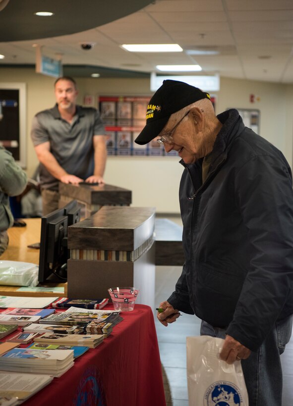 Eugene Piontkawski, health fair guest, looks at the Airman and Family Readiness Center information table during the 436th Medical Group Health Fair on Nov. 27, 2018, at Dover Air Force Base, Del. Attendees were offered free medical information on topics such as diabetes, disease management, dental health and cervical cancer. (U.S. Air Force photo by Airman 1st Class Zoe M. Wockenfuss)