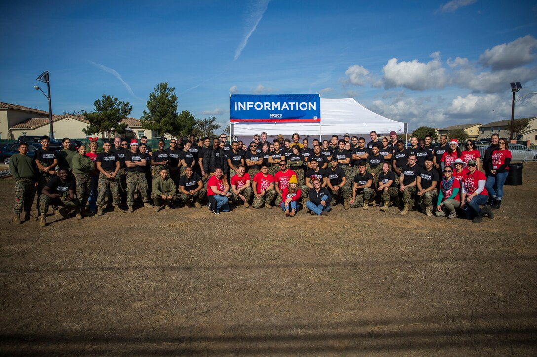 U.S. Marines, and Marine Corps Community Service employees take a group photo following the Trees for Troops event at Marine Corps Base Camp Pendleton, California, Dec. 1, 2018. The event provided service members and their families an opportunity to celebrate the holiday season and the chance to take a Christmas tree home. (U.S. Marine Corps photo by Cpl. Dylan Chagnon)