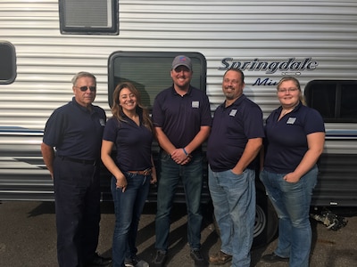 Members of the Outdoor Recreation Team stand in front of a rentable trailer.