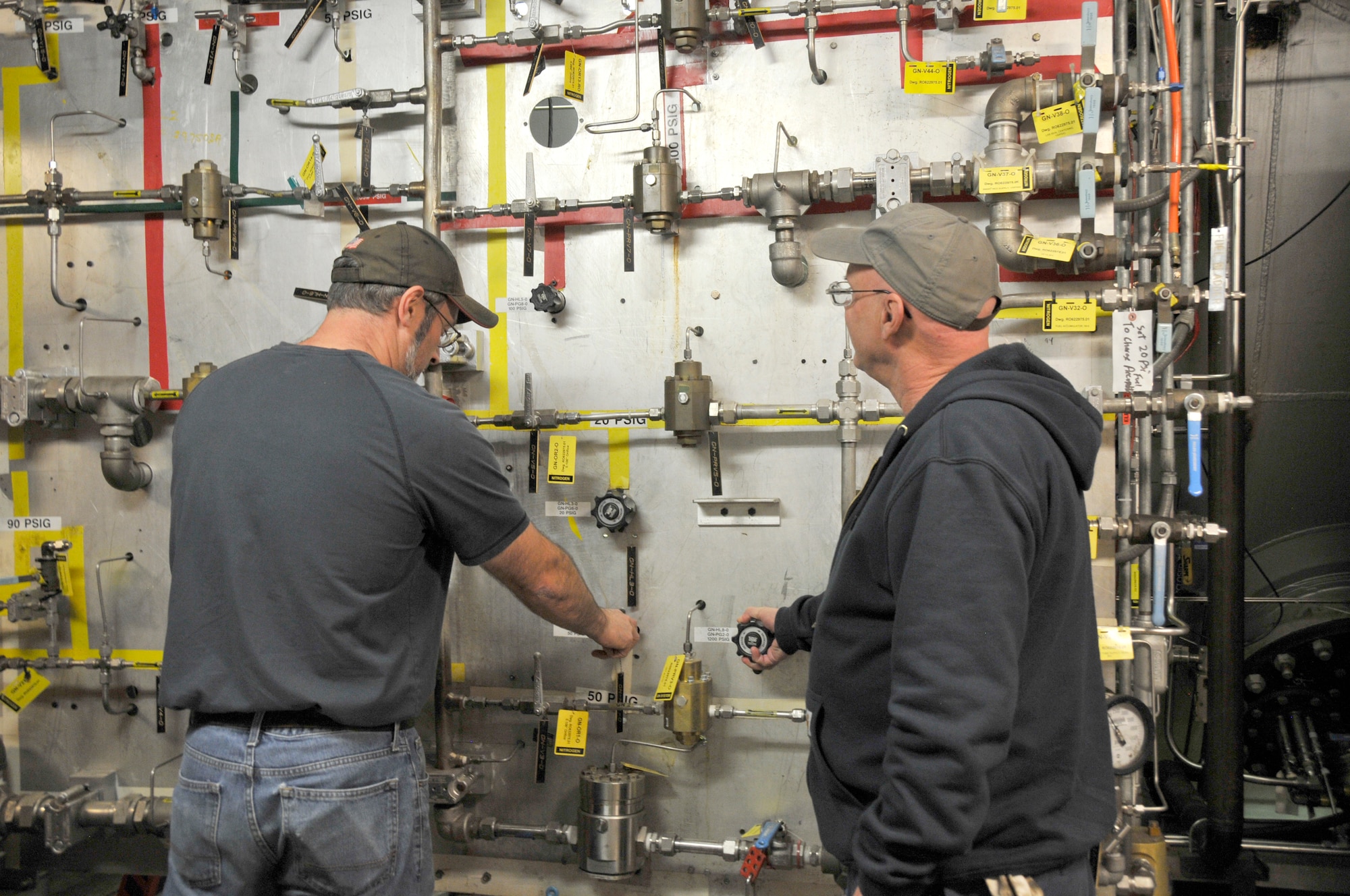 Drew Hall and Neil Aukeman, outside machinists for the Aeropropulsion System Test Facility, check vavles for C-1 and C-2 engine test cells at Arnold Air Force Base. (U.S. Air Force photo by Deidre Ortiz)