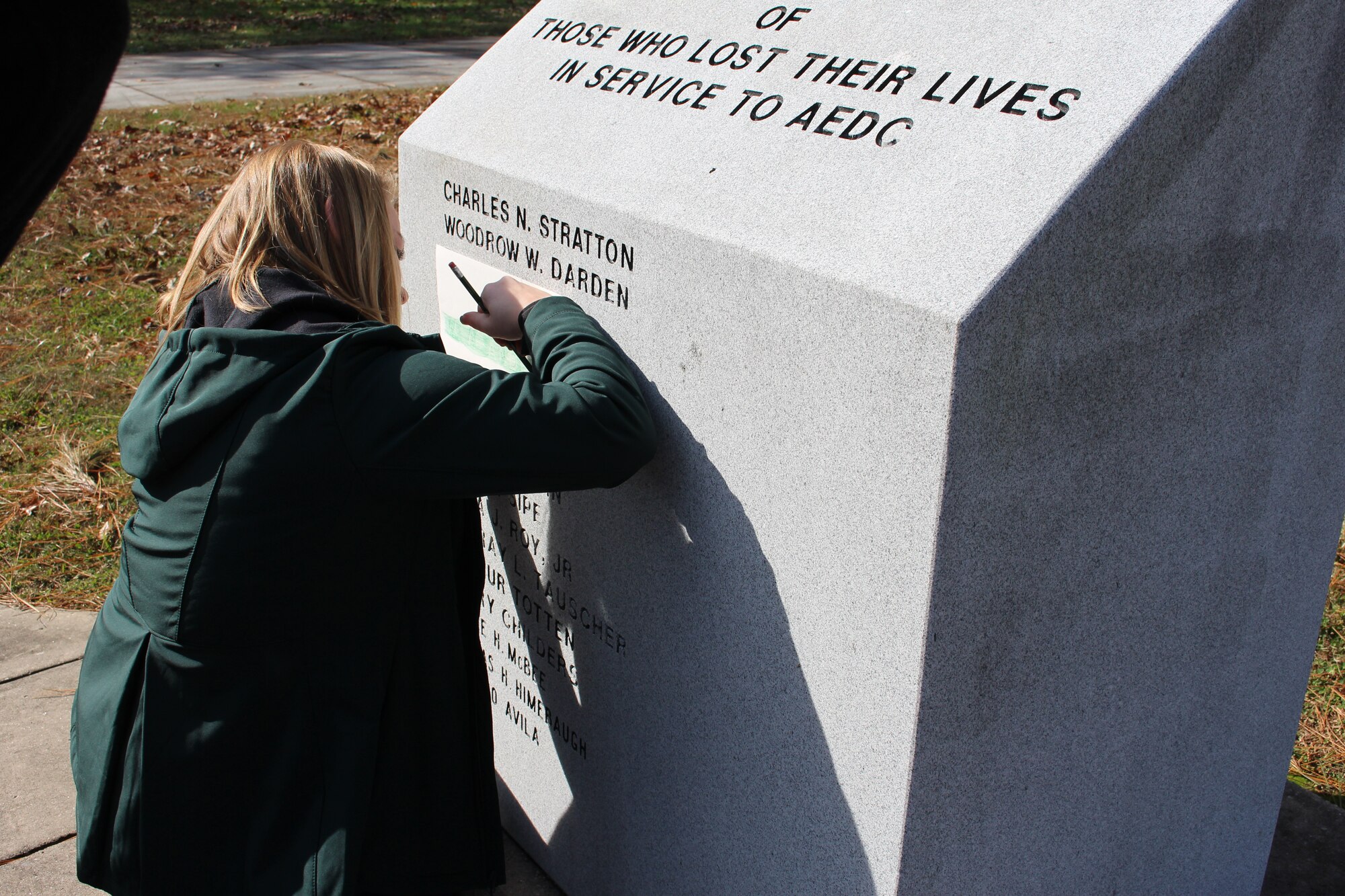 Julie Gesell, granddaughter of the late Wilmer Adam Anderson, an AEDC concrete laborer, sketches the name of her grandfather when visiting the memorial outside the Administration and Engineering Building Nov. 16. Anderson was among four AEDC team members who tragically lost their lives in an accident Dec. 17, 1962, at the J-4 liquid rocket test cell. The memorial is dedicated to all individuals who have lost their lives in service to AEDC. (U.S. Air Force photo by Deidre Ortiz)