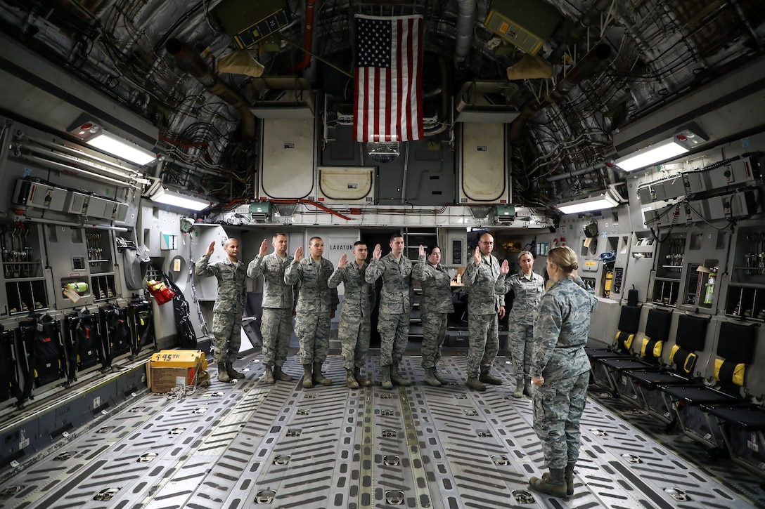 Capt. Beth Shuler, 445th Force Support Squadron, administers the Oath of Enlistment to eight reservists during a re-enlistment ceremony held onboard a 445th Airlift Wing C-17 Globemaster III last month.