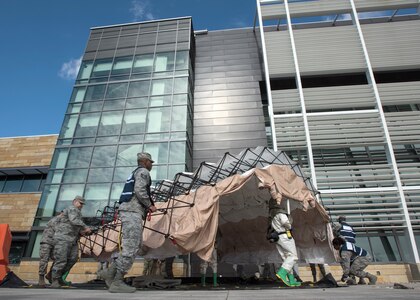 Medics set up a decontamination tent during a MASCAL exercise on Joint Base San Antonio-Lackland, Texas. The exercise tested the clinical and field response teams’ communication efficiency between wing personnel and the medical control center. (U.S. Air Force photo by Staff Sgt. Kevin Iinuma)