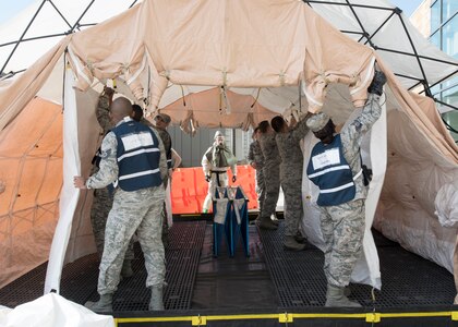 Medics set up a decontamination tent during a MASCAL exercise on Joint Base San Antonio-Lackland, Texas. The exercise tested the clinical and field response teams’ communication efficiency between wing personnel and the medical control center. (U.S. Air Force photo by Staff Sgt. Kevin Iinuma)