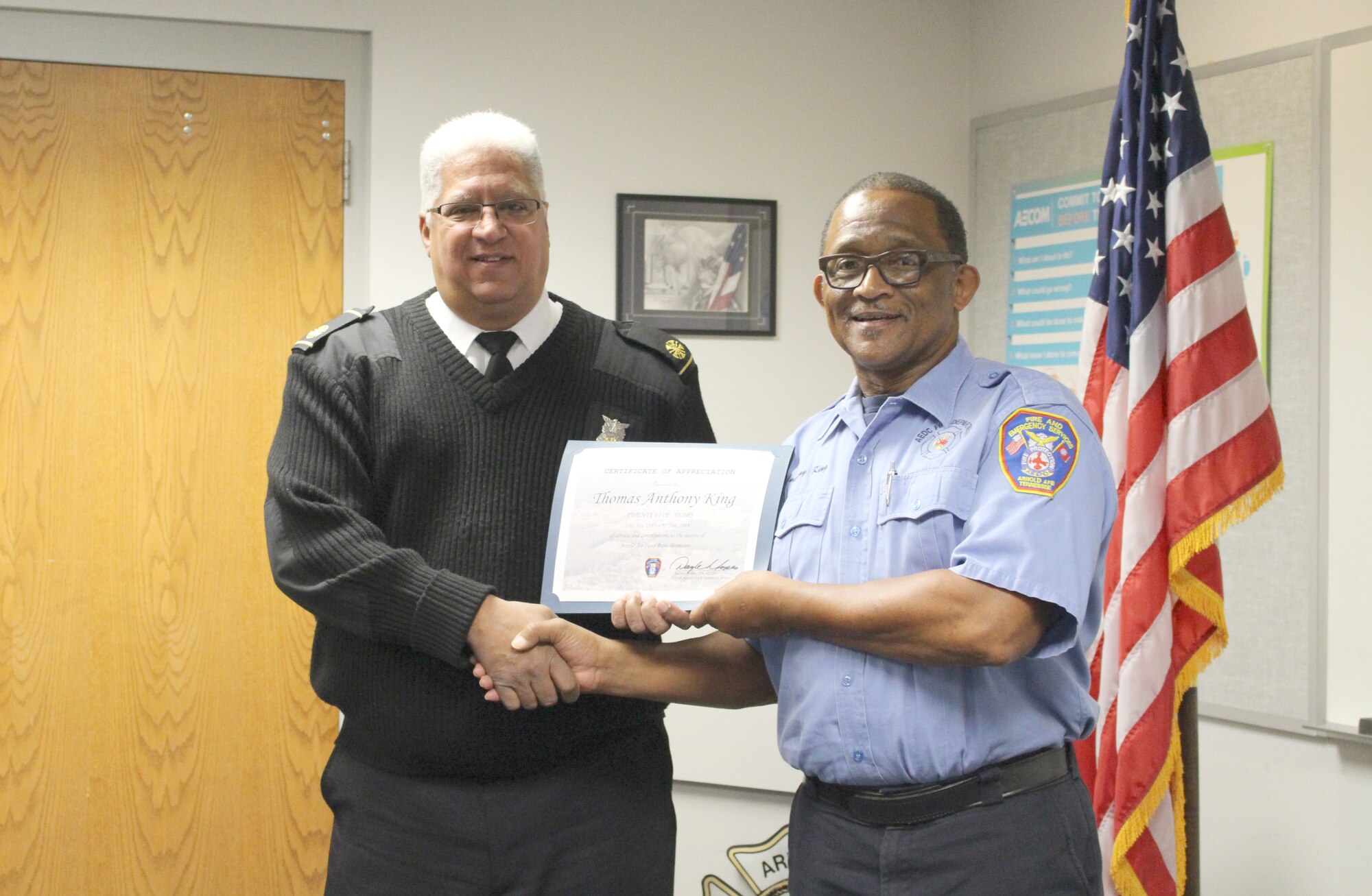 Thomas Anthony King, right, firefighter for Arnold Air Force Base Fire and Emergency Services, receives a certificate recognizing his 25 years of service from Daryle Lopes, chief of Arnold Fire and Emergency Services. (U.S. Air Force photo by Deidre Ortiz)