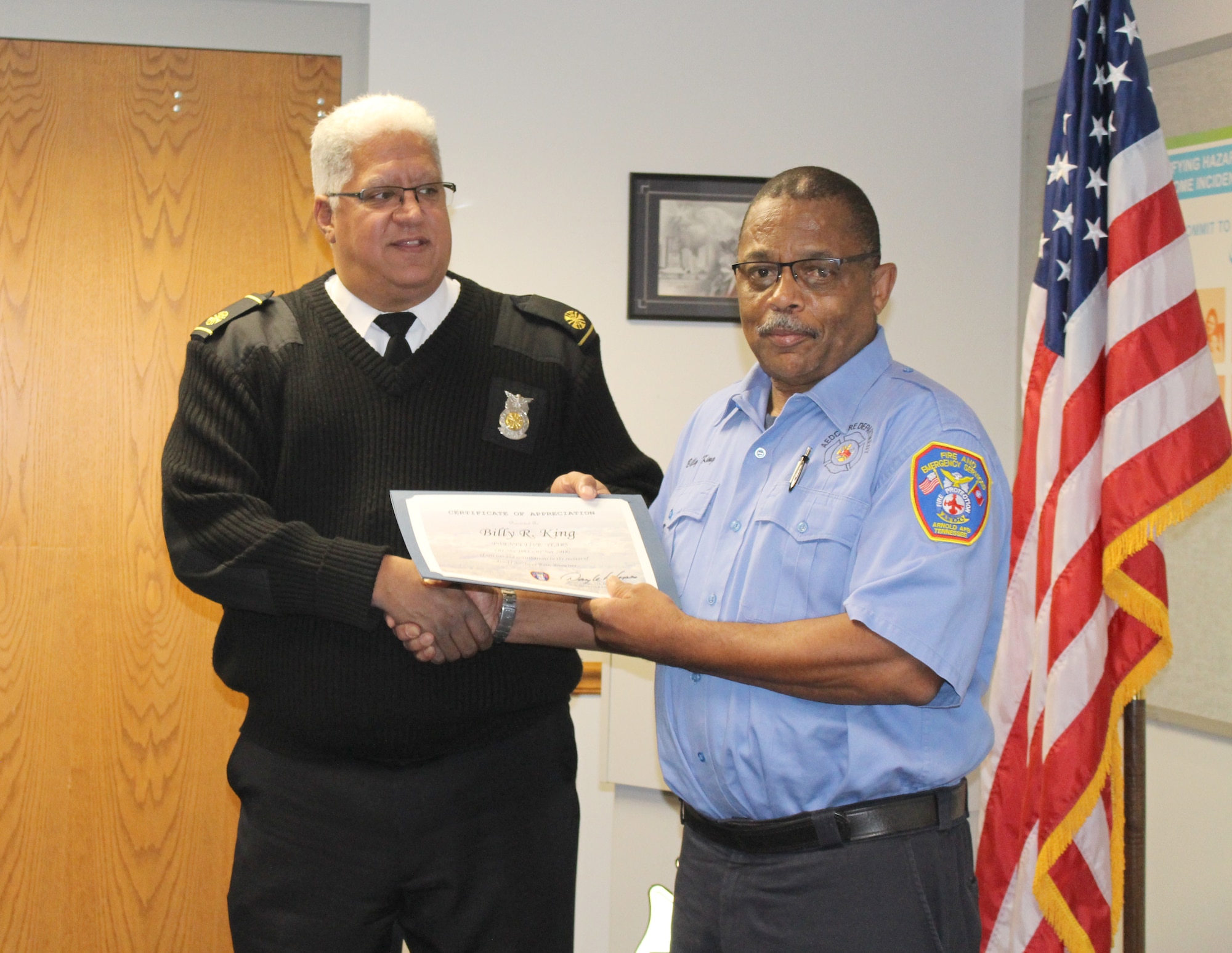 Billy King, right, firefighter for Arnold Air Force Base Fire and Emergency Services, receives a certificate recognizing his 25 years of service from Daryle Lopes, chief of Arnold Fire and Emergency Services. (U.S. Air Force photo by Deidre Ortiz)
