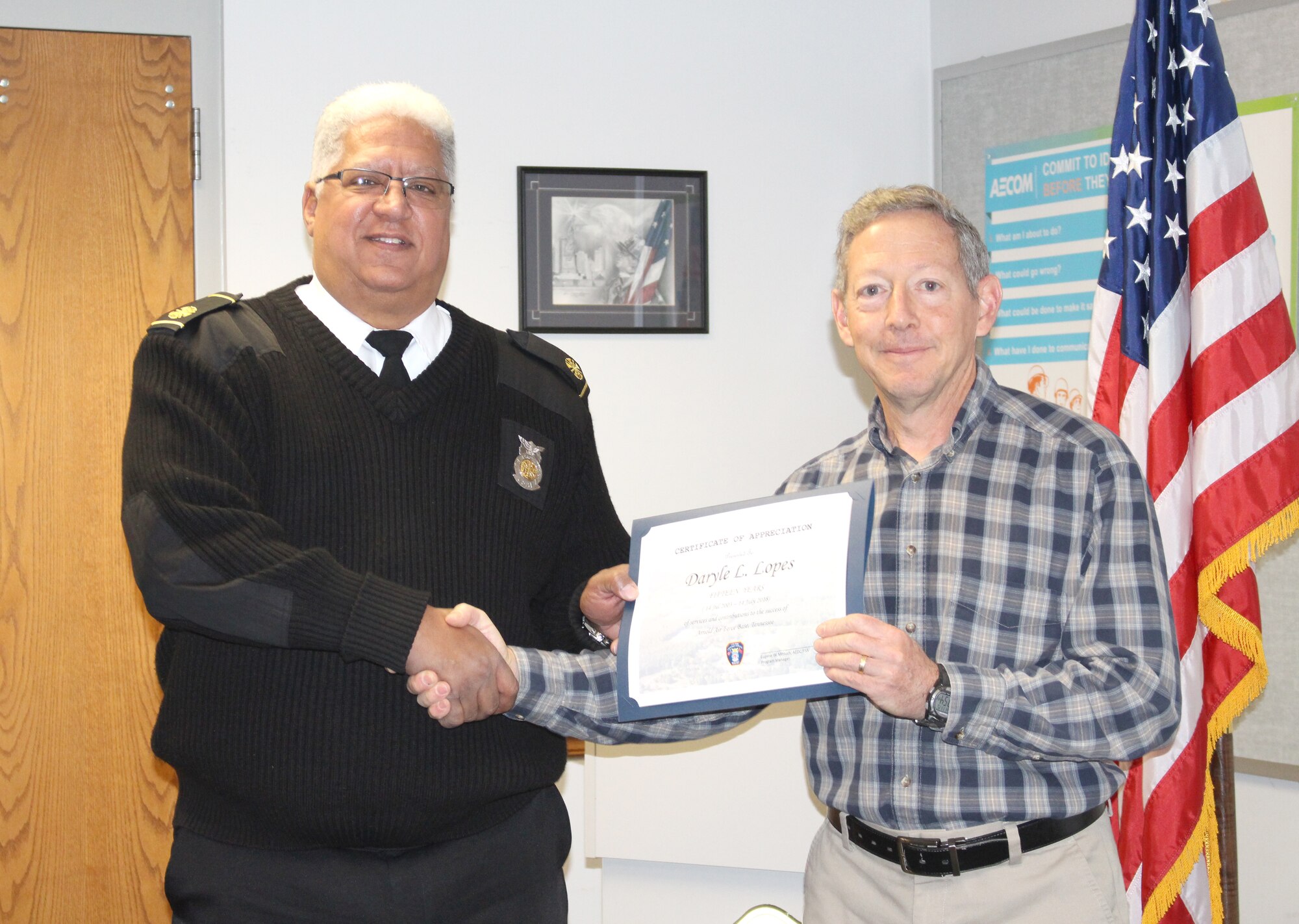 Daryle Lopes, left, chief of Arnold Fire and Emergency Services, receives a certificate recognizing his 15 years of service from Eugene Mittuch, project manager of the Facility Support Services contract at Arnold Air Force Base. (U.S. Air Force photo by Deidre Ortiz)