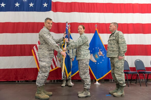 Col. Erik Peterson, the commander of the 115th Fighter Wing, presents the guidon to Lt. Col. Wilhelmina Panzer, the new commander of the 115th Maintenance Group, during the 115 MXG change of command ceremony Dec. 2, 2018, at the 115th Fighter Wing, Truax Field, Wisconsin. Lt. Col. Panzer was previously the inspector general at the 115th Fighter Wing before taking command of the maintenance group.  (U.S. Air National Guard photo by Airman 1st Class Cameron Lewis)