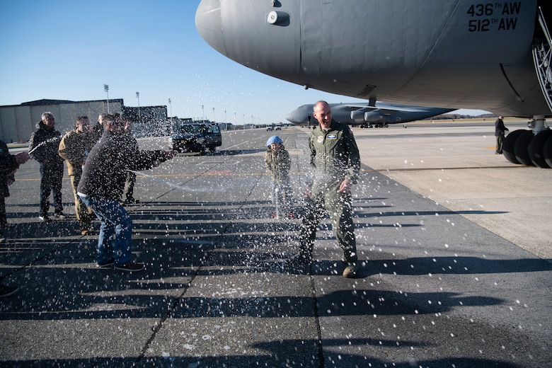 Chief Master Sgt. Larry C. Williams, Air Mobility Command command chief, receives the traditional hose-down from family, friends and base personnel after his final flight in a C-5M Super Galaxy Nov. 29, 2018, at Dover Air Force Base, Del. Williams is retiring after serving more than 30 years in the Air Force. (U.S. Air Force photo by Airman 1st Class Zoe M. Wockenfuss)