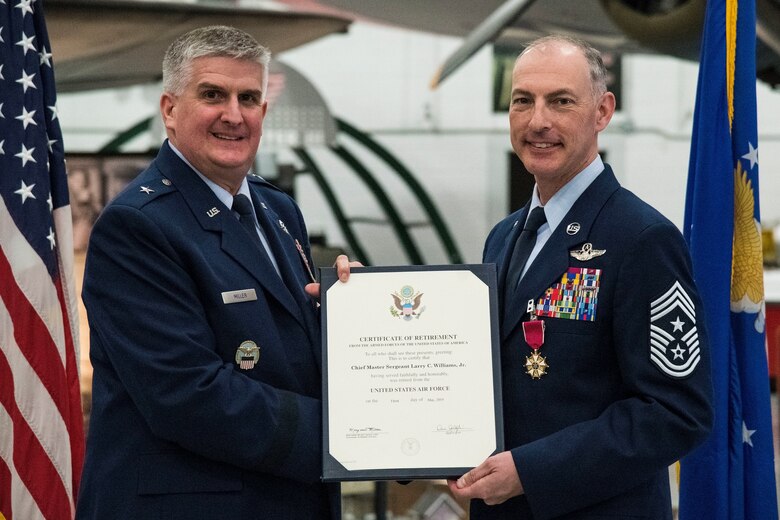 Brig. Gen. Albert Miller, left, commander, Defense Logistics Agency, Energy, Ft. Belvoir, Va., presents Chief Master Sgt. Larry Williams, Air Mobility Command command chief, his Certificate of Retirement  during Williams' retirement ceremony Nov. 30, 2018, at the Air Mobility Command Museum on Dover Air Force Base, Del. Miller was the officiating officer for the ceremony which paid special tribute to Williams' distinguished Air Force career spanning over 30 years of dedicated service to the nation. (U.S. Air Force photo by Roland Balik)