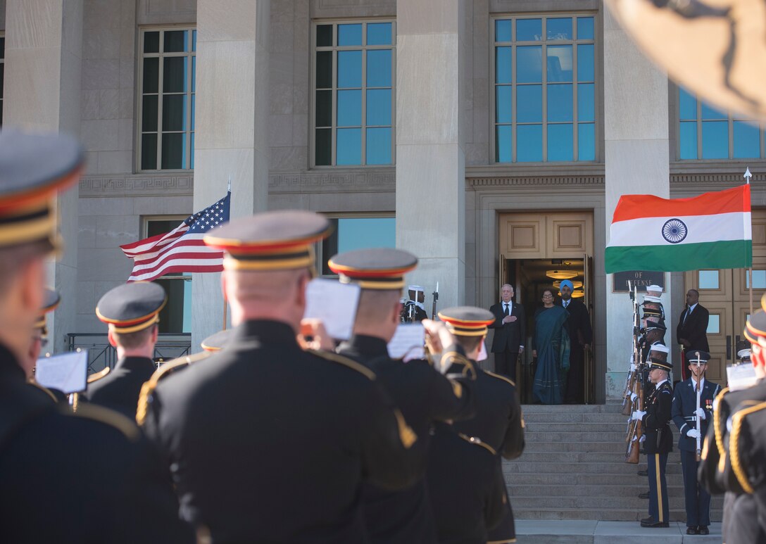 U.S. defense secretary and Indian minister of defense stand at the top of stairs.
