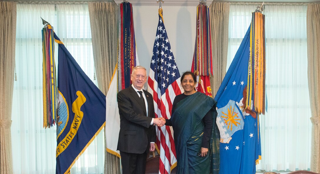 U.S. defense secretary shakes hands with Indian minister of defense.