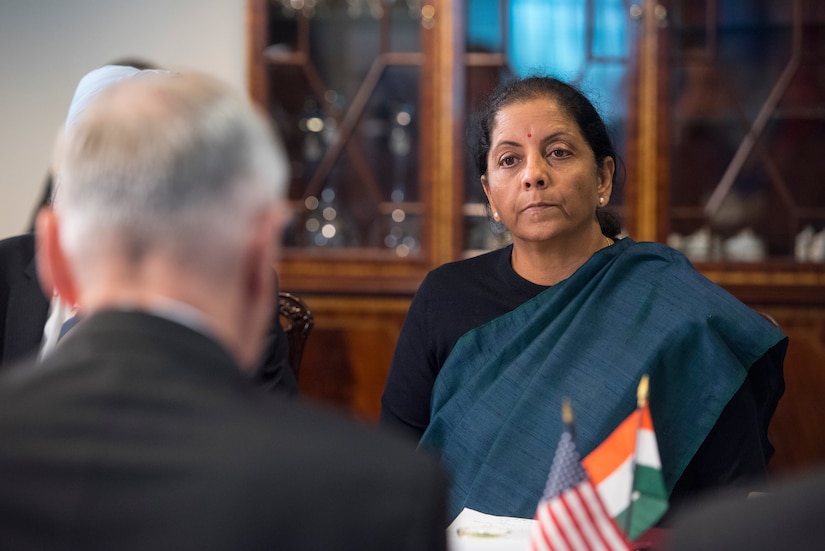 U.S. defense secretary sits at table with Indian minister of defense.