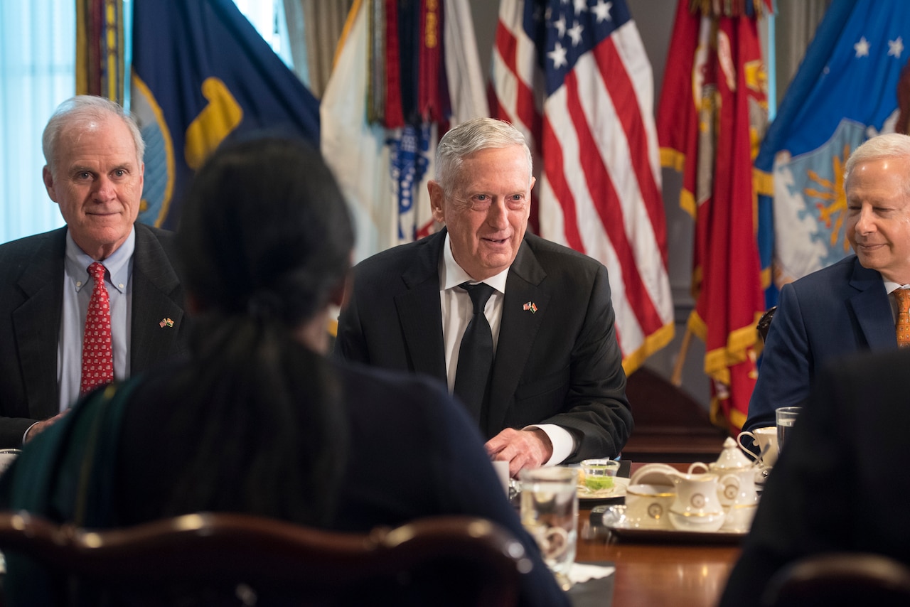 U.S. defense secretary sits at table with Indian minister of defense.