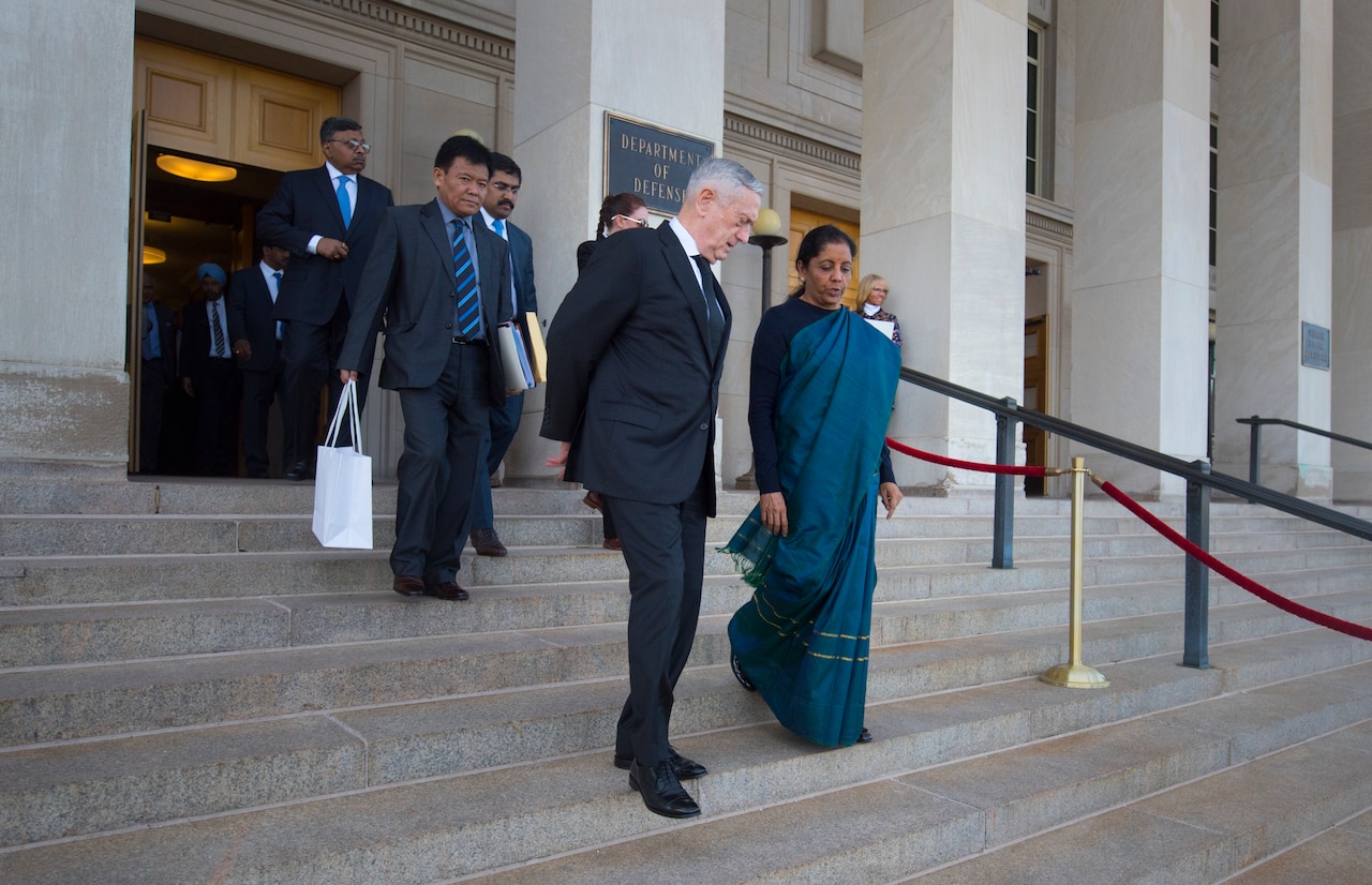 Defense Secretary James N. Mattis walks down steps of the Pentagon steps with Indian Defense Minister Nirmala Sitharaman.