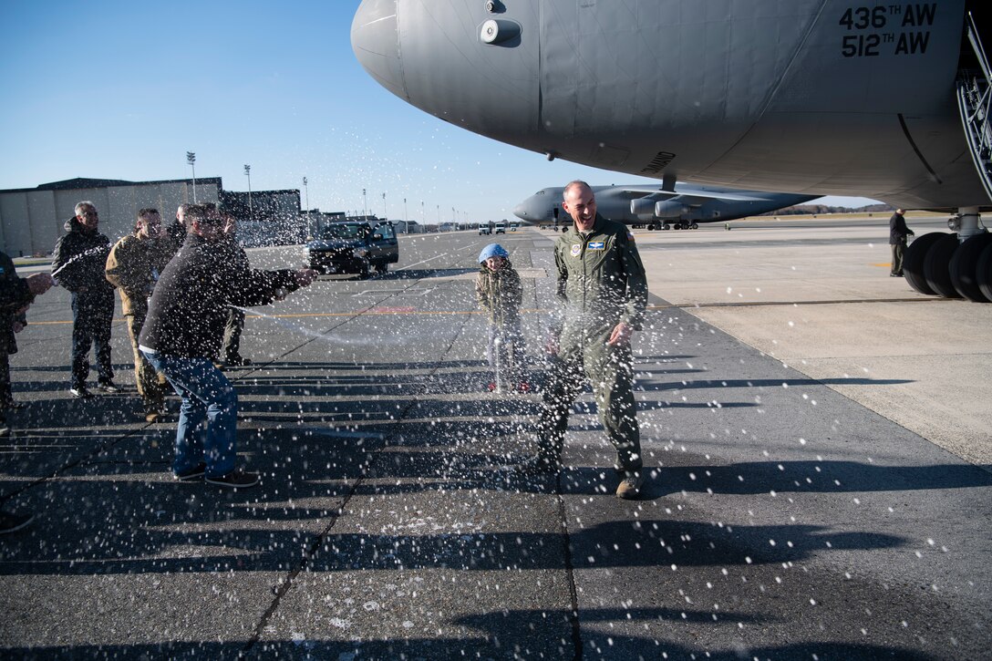 Chief Master Sgt. Larry C. Williams, Air Mobility Command command chief, receives the traditional hose-down from family, friends and base personnel after his final flight in a C-5M Super Galaxy Nov. 29, 2018, at Dover Air Force Base, Del. Williams is retiring after serving more than 30 years in the Air Force. (U.S. Air Force photo by Airman 1st Class Zoe M. Wockenfuss)