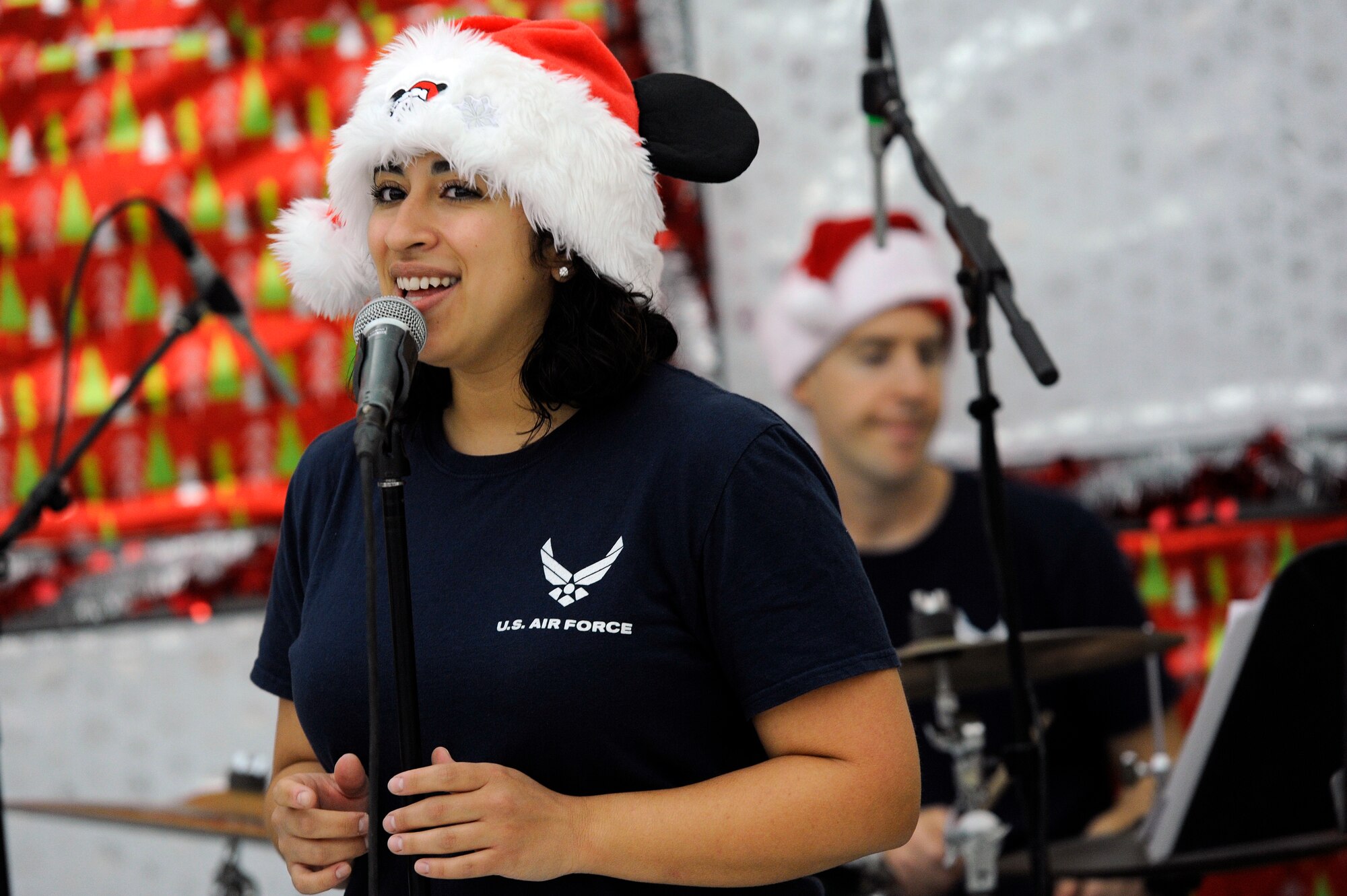 U.S. Air Force Senior Airman Alycia Cancel, U.S. Air Forces Central Command Band vocalist, sings a holiday song during a holiday kick-off event Dec. 1, 2018, at Al Udeid Air Base, Qatar. Service members and their families were able to play holiday games, watch live music performances, interact with Santa Claus and watch a tree lighting ceremony, during the event. (U.S. Air Force photo by Tech. Sgt. Christopher Hubenthal)