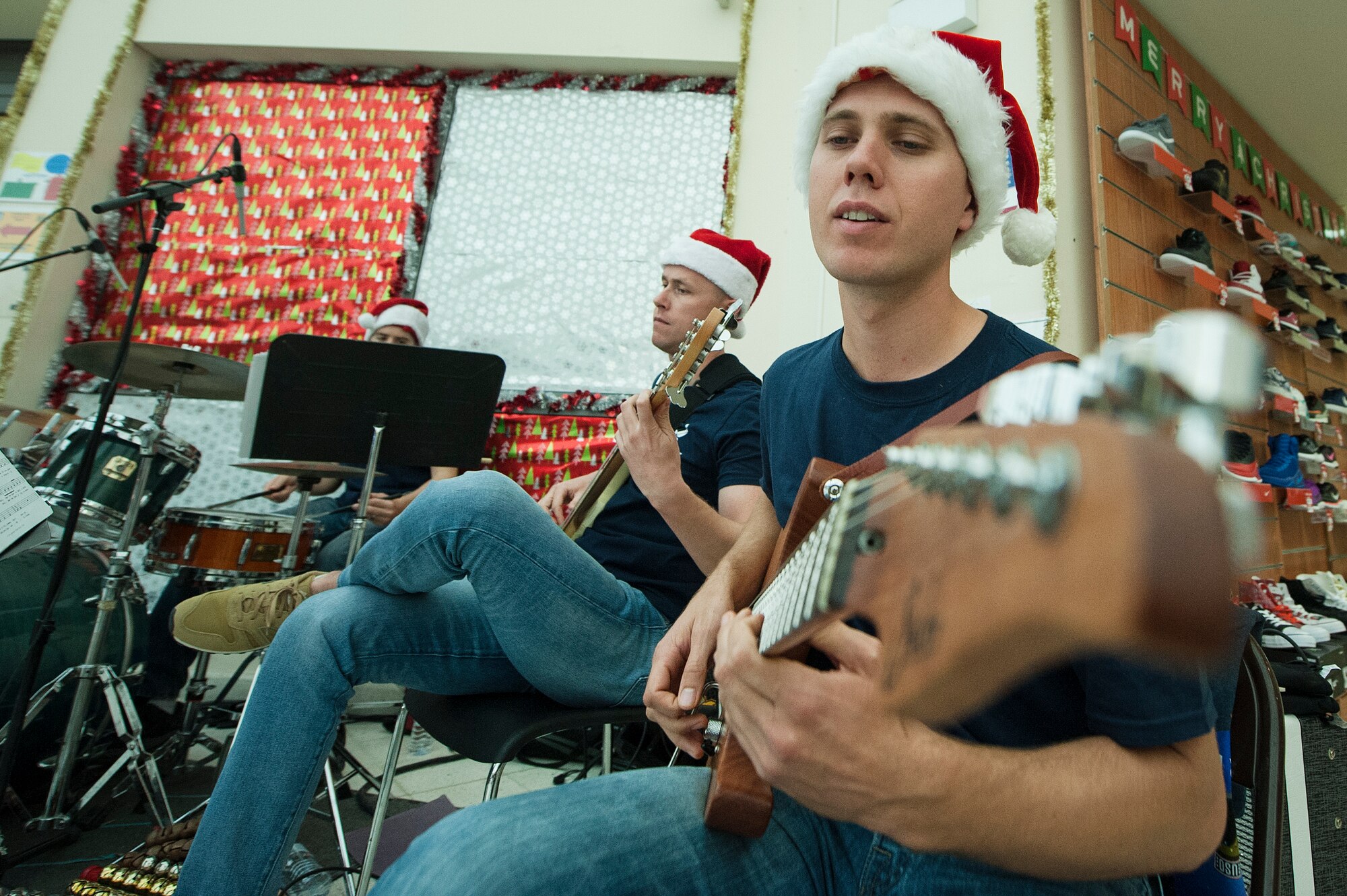 U.S. Air Force Senior Airman Guy James, foreground, U.S. Air Forces Central Command Band guitarist, and Staff Sgt. Bryan Andrews, AFCENT Band bassist, play holiday songs during a holiday kick-off event Dec. 1, 2018, at Al Udeid Air Base, Qatar. Service members and their families were able to play holiday games, watch live music performances, interact with Santa Claus and watch a tree lighting ceremony, during the event. (U.S. Air Force photo by Tech. Sgt. Christopher Hubenthal)