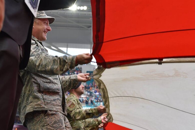 Airmen and local community members unfurl the flag for the National Anthem prior to the start of a Miami Dolphins football game on Dec 2, 2018 in Miami. Approximately 75 Airmen from Patrick Air Force Base, Fla. participated in the event. (U.S. Air Force photo by Tech. Sgt. Andrew Satran)