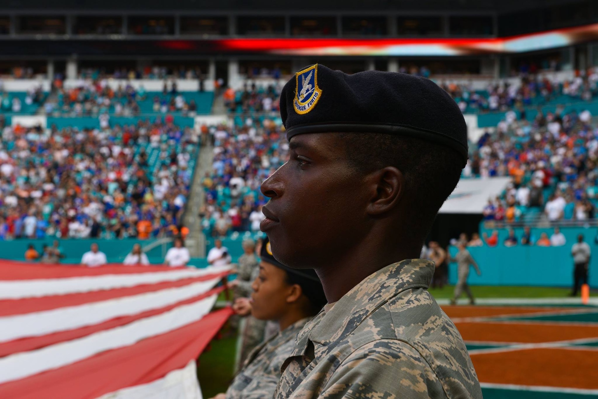 Airmen and local community members unfurl the flag for the National Anthem prior to the start of a Miami Dolphins football game on Dec 2, 2018 in Miami. Approximately 75 Airmen from Patrick Air Force Base, Fla. participated in the event. (U.S. Air Force photo by Airman 1st Class Dalton Williams)