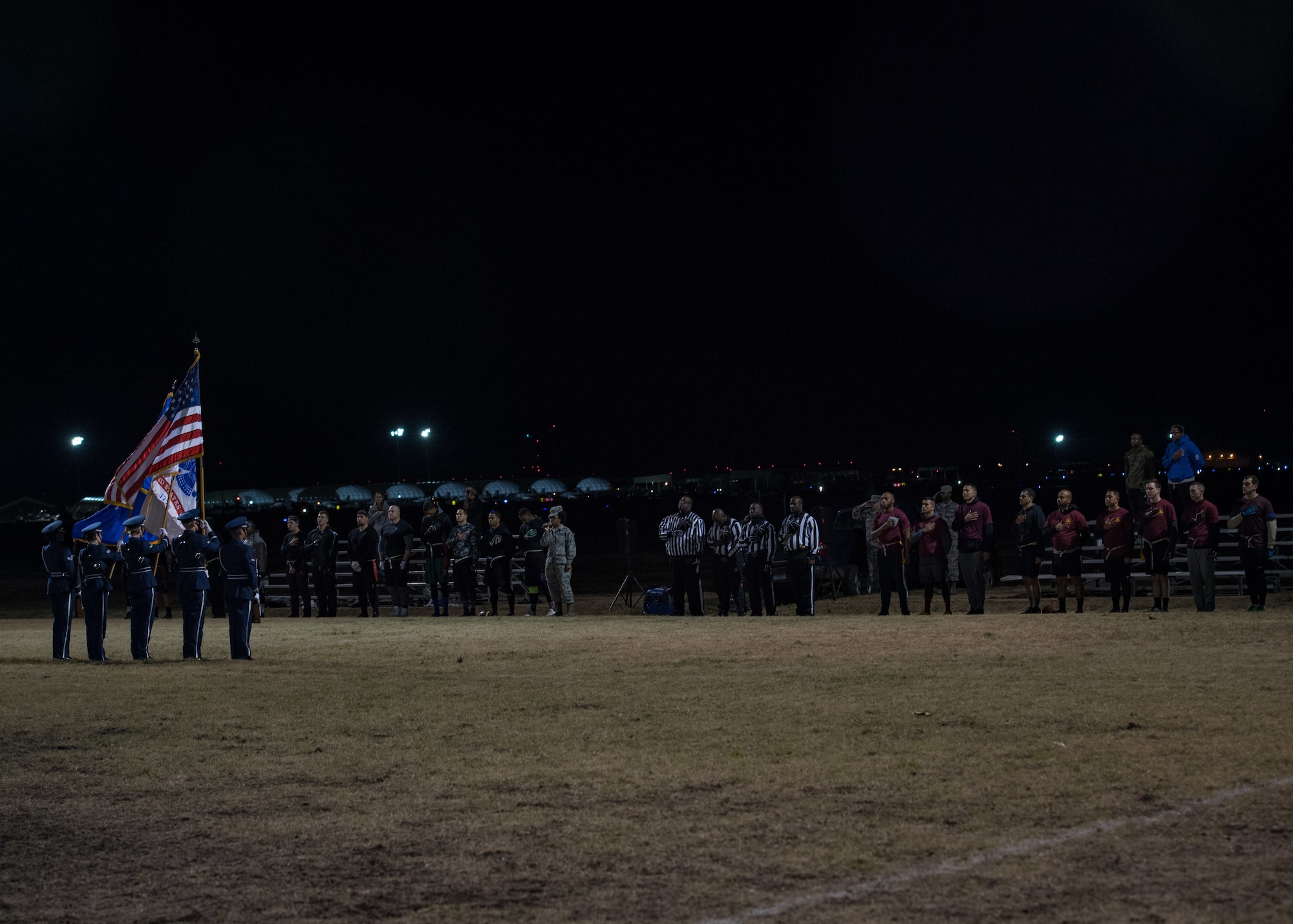 Players assigned to the 633rd Medical Group and 27th Intelligence Squadron hold their hands over their hearts during the singing of the national anthem before the intramural flag-football championship at Joint Base Langley-Eustis, Virginia, Nov. 27, 2018.