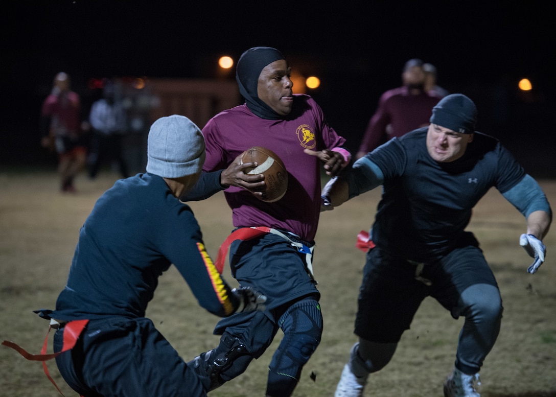 U.S. Air Force Master Sgt. Masai Dafar, 27th Intelligence Squadron coach, attempts to rush past defensive players assigned to the 633rd Medical Group during the intramural flag-football championship at Joint Base Langley-Eustis, Virginia, Nov. 27, 2018.