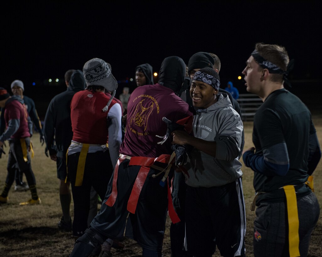 U.S. Air Force Airmen assigned to the 633rd Medical Group and 27th Intelligence Squadron hug during the intramural flag-football championship at Joint Base Langley-Eustis, Virginia, Nov. 27, 2018.
