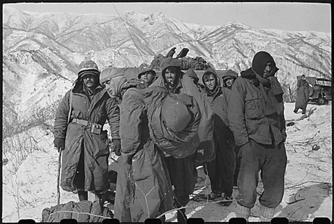 A black and white photo of Marines standing in the snow.