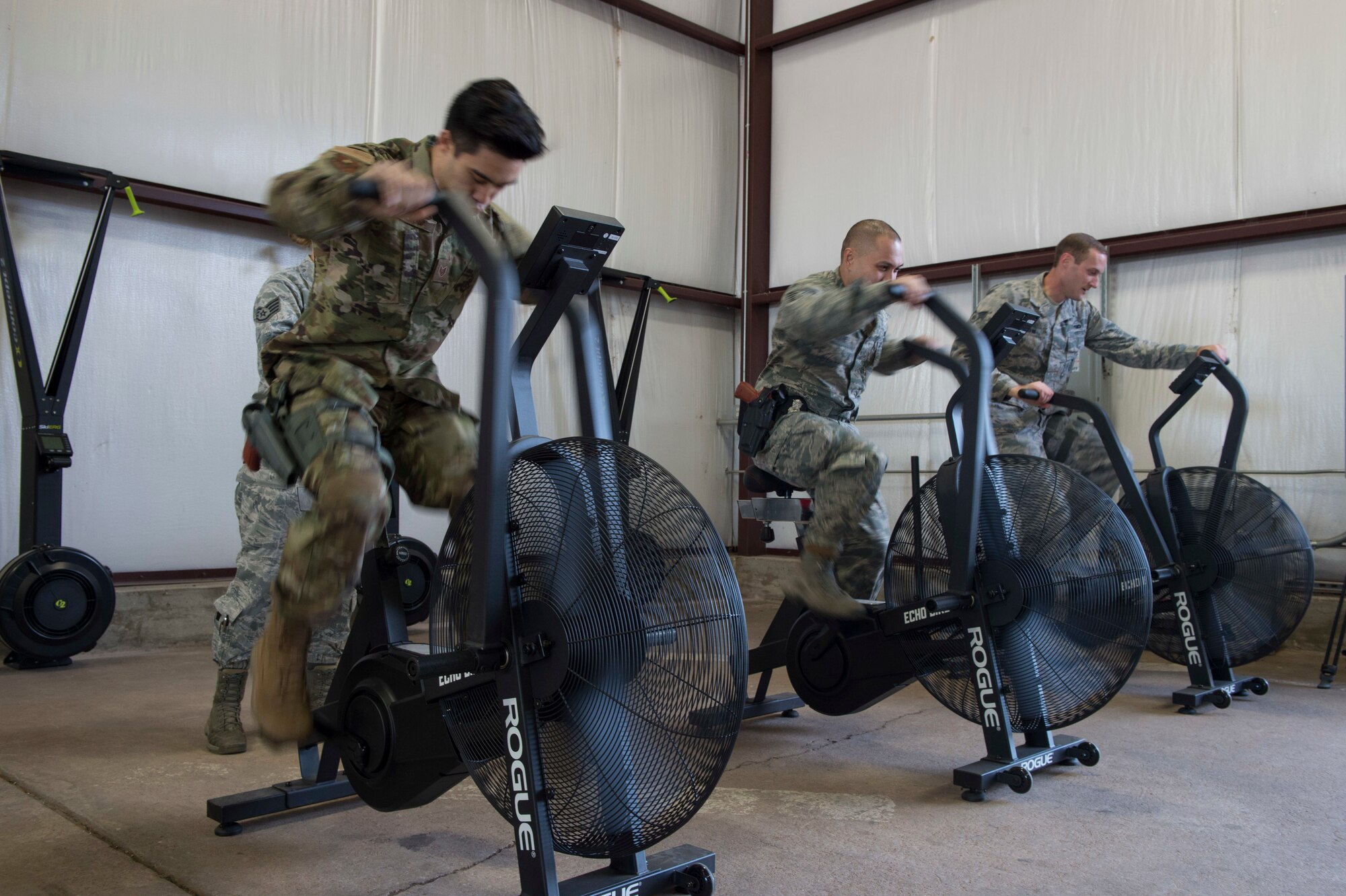 Members of 97th Security Forces Squadron staff support team use exercise bikes