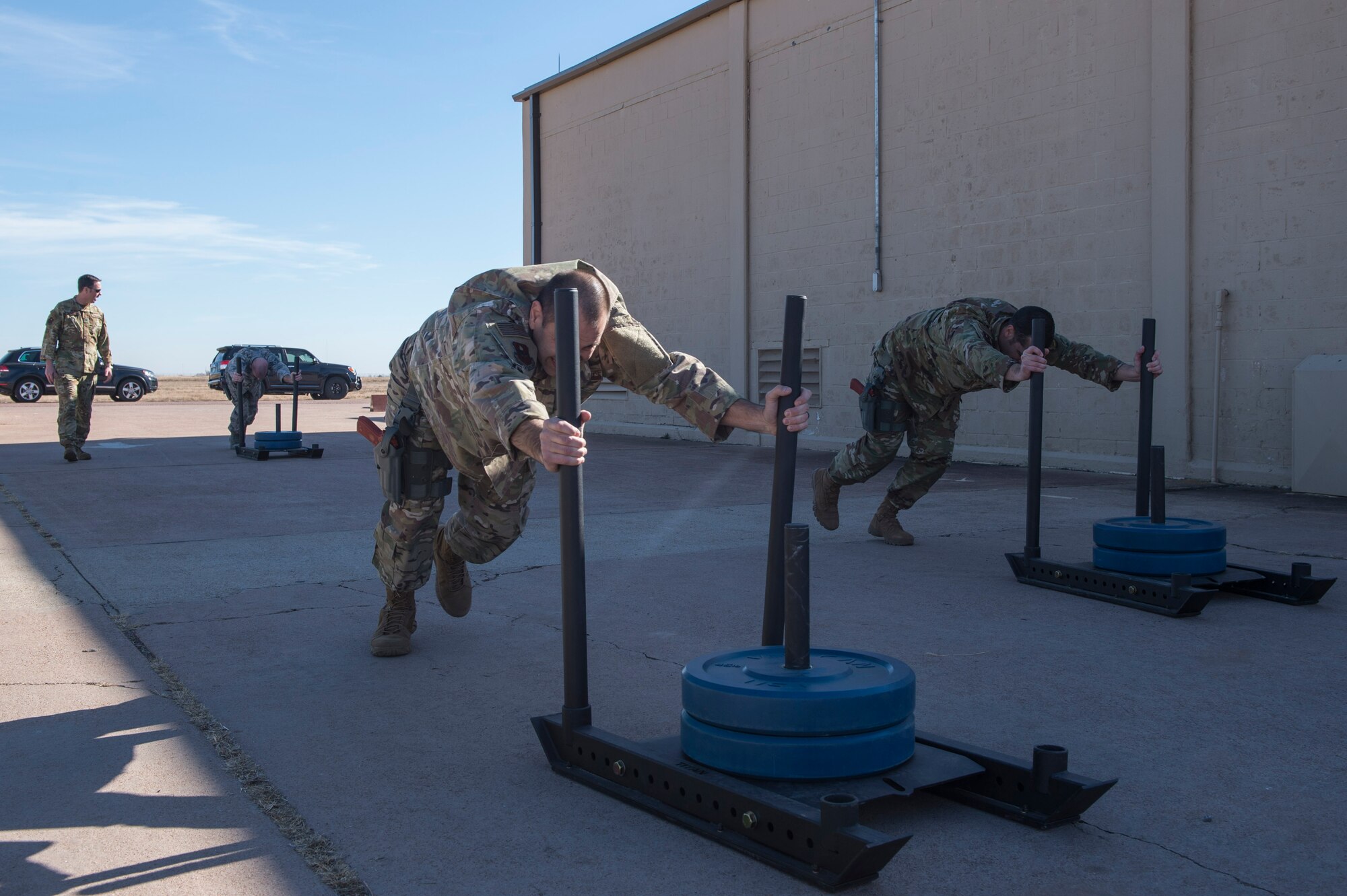 Members of the 97th Force Support Squadron team push weighted sleds