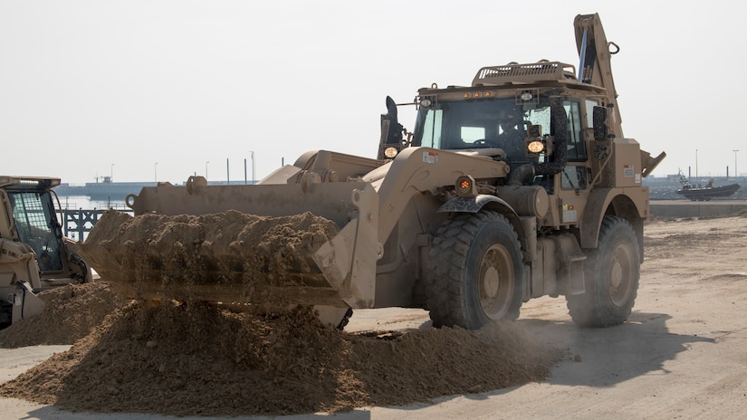 U.S. Army Spc. Daniel Boyet, a heavy equipment operator with Alpha Company, 150th Brigade Engineer Battalion, Mississippi Army National Guard, uses a High Mobility Engineer Excavator to move sand into a position where it can be used to fill in a ditch created by rainwater runoff at the beach at Kuwait Naval Base, Kuwait, Nov. 30, 2018. The hazard created by the ditch made the beach unsafe for training until the 150th BEB was able to fix it with help from Area Support Group-Kuwait's Directorate of Public Works.