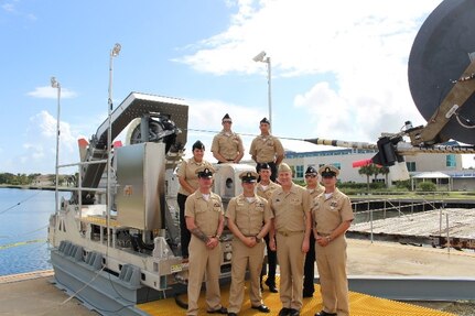 Rear Adm. John Neagley, Program Executive Officer for Unmanned and Small Combatants, poses with sailors attached to USS Forth Worth (LCS 3) at a test event for the DART mission system at the Harbor Branch Oceanographic
Institute in Fort Pierce, Florida.