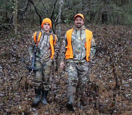 Eli and Randy Randolph don blaze orange, a crossbow, and backpack of gear as they hike to their staked-out hunting location in Carthage, Tenn., Dec. 1, 2018.  (USACE photo by Ashley Webster)