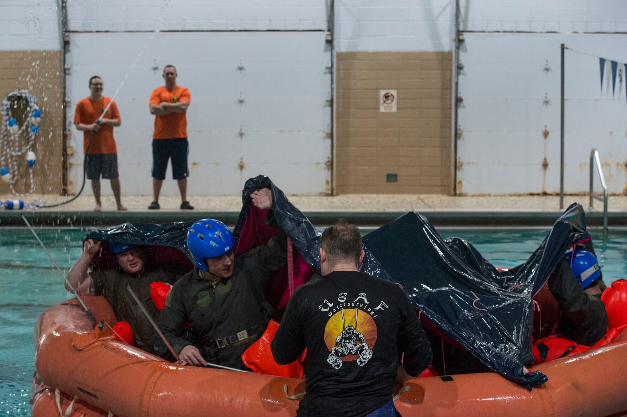 U.S. Air Force Staff Sgt. Mark Belcher, the NCO in charge of continuation training assigned to the 97th Operations Squadron, instructs members on setting up an F-2B raft canopy during a water survival refresher course,