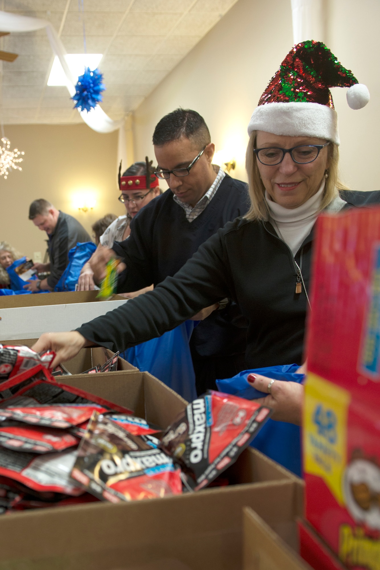 Members of the local community fill gift bags at the Bellevue Volunteer Fire Department Dec. 4, 2018. The bags are part of Operation Holiday Cheer, an annual event sponsored by the Bellevue Chamber of Commerce, where gift bags are assembled for Offutt Air Force Base dormitory residents. (U.S. Air Force photo by L. Cunningham)