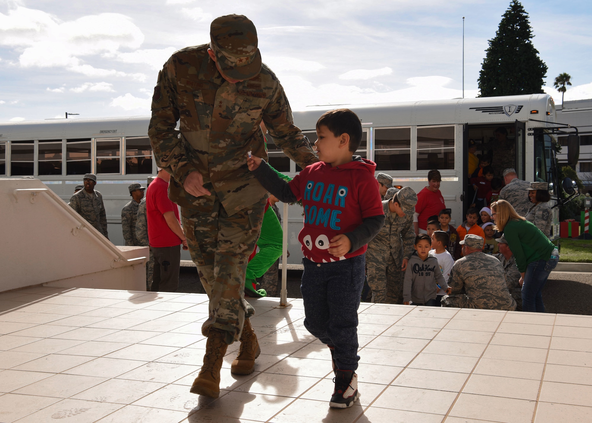 Maj. Gen. Stephen Whiting, 14th Air Force commander and Deputy Joint Force Space Component commander, walks with a child into the Pacific Coast Club during Operation Kids Christmas at Vandenberg Air Force Base, Calif. Dec. 1, 2018. Vandenberg hosts the 59th annual Operation Kids Christmas here, expecting 200 kids from nearby cities to partake in the planned games, crafts, lunch and Christmas gifts.
