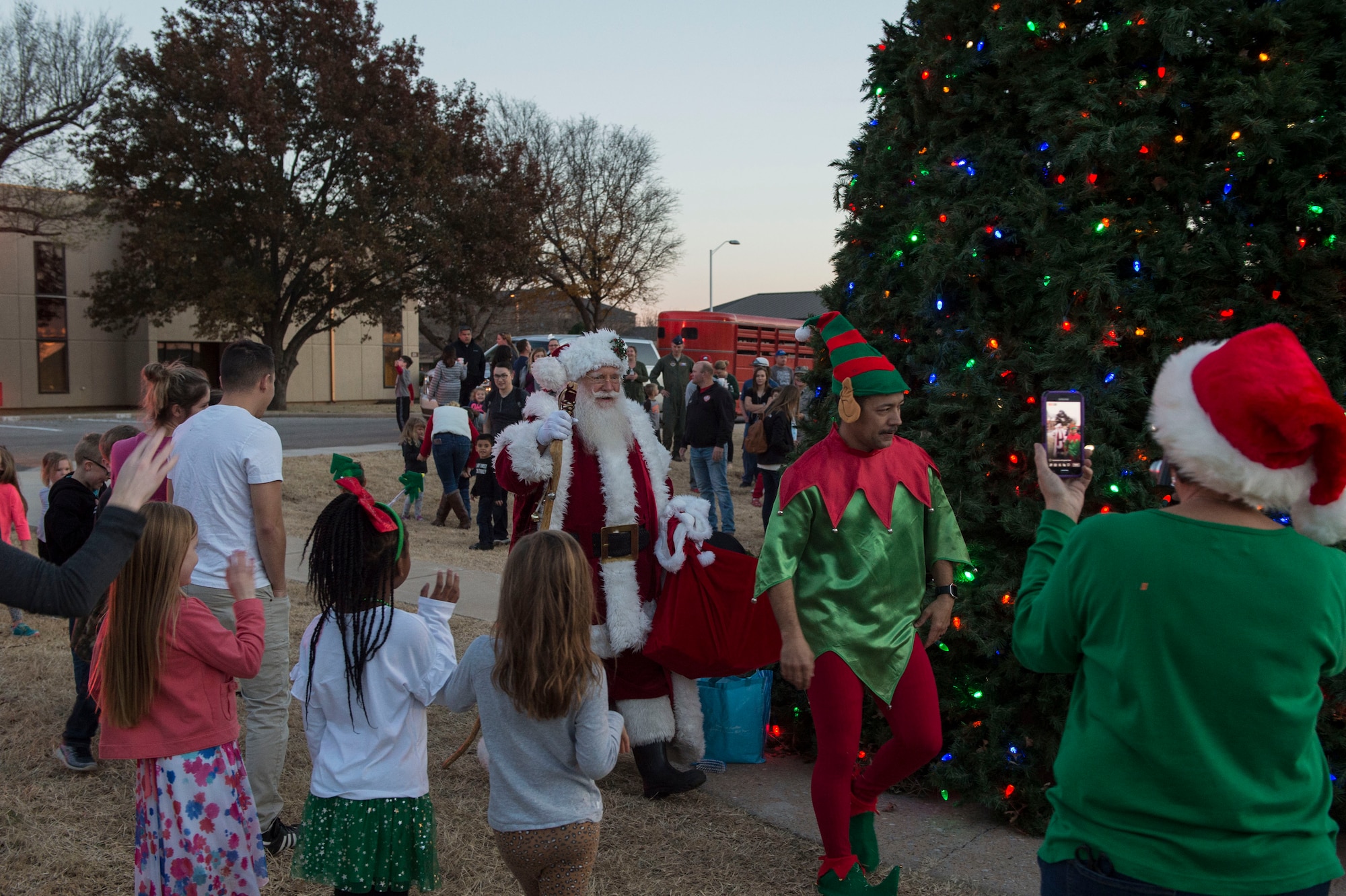 Members of the 97th Air Mobility Wing gather to greet Santa Claus, Nov. 29, 2018, at Altus Air Force Base, Okla. After the holiday tree is lit, Santa Claus greets the members of the 97th AMW after arriving in a firetruck. (U.S. Air Force photo by Senior Airman Cody Dowell)
